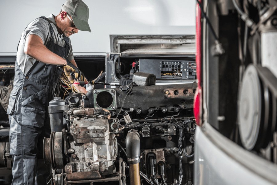Diesel mechanic working on a Class 8 engine in the shop